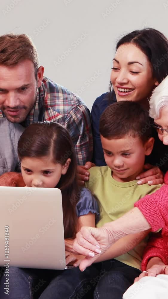 Smiling multi generation family using laptop Smiling multi generation family using laptop