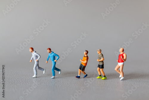 Close-up of tiny figurines of runners in colorful sportswear, depicting an active lifestyle. Concept of fitness, movement, and motivation.