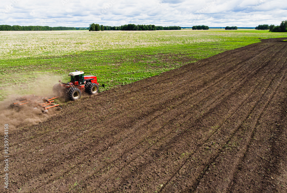large agricultural machine cultivates the land. The view from the top. Plowing land for planting crops. photos from the bird's eye view with a quadcopter large agricultural machine cultivates the land. The view from the top. Plowing land for planting crops. photos from the bird's eye view with a quadcopter