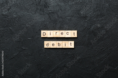 direct debit word written on wood block. direct debit text on cement table for your desing, concept