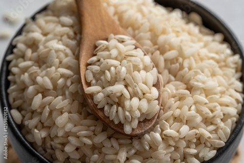 Arborio rice closeup photography. Closeup of arborio short grain rice. Rice in wooden spoon closeup.