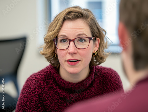 woman with glasses and red sweater engages in conversation, showing trust and openness
