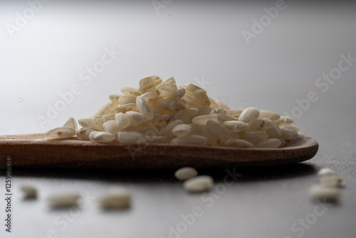 Macro photography of white rice. Rice in wooden spoon. Closeup of white rice 