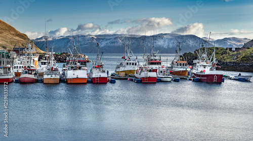 fishing boats in harbour and  water surrouded by mountains in norway on Mager...