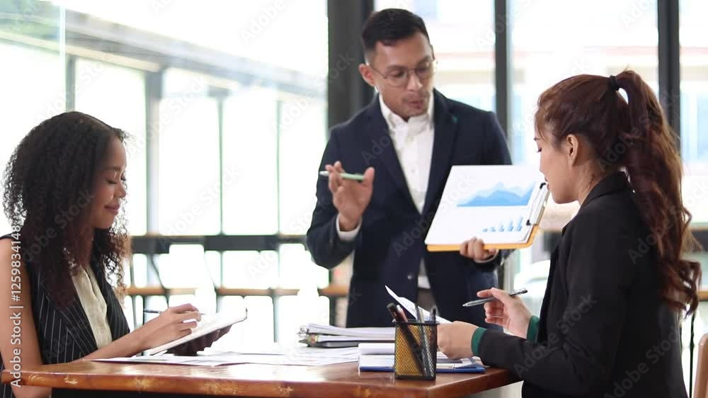 Asian businessman plans meeting with documents for brainstorming table work at office. Businessman, woman and coworkers with documents for discussion. Asian businessman plans meeting with documents for brainstorming table work at office. Businessman, woman and coworkers with documents for discussion.
