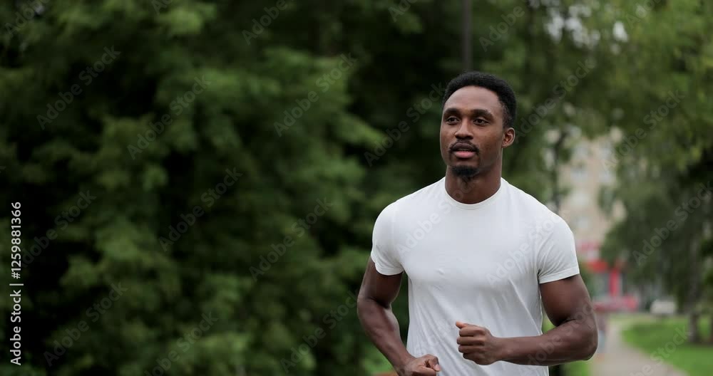 Fitness man running outdoor on park street. Young black man in fitness wear and running in the park at morning. Healthy lifestyle concept. Fitness man running outdoor on park street. Young black man in fitness wear and running in the park at morning. Healthy lifestyle concept.