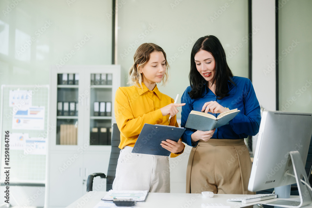 Two business workers talking on the smartphone and using laptop at the office.. Two business workers talking on the smartphone and using laptop at the office..