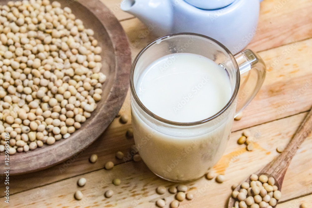 a glass of soy milk with soy beans on the table a glass of soy milk with soy beans on the table