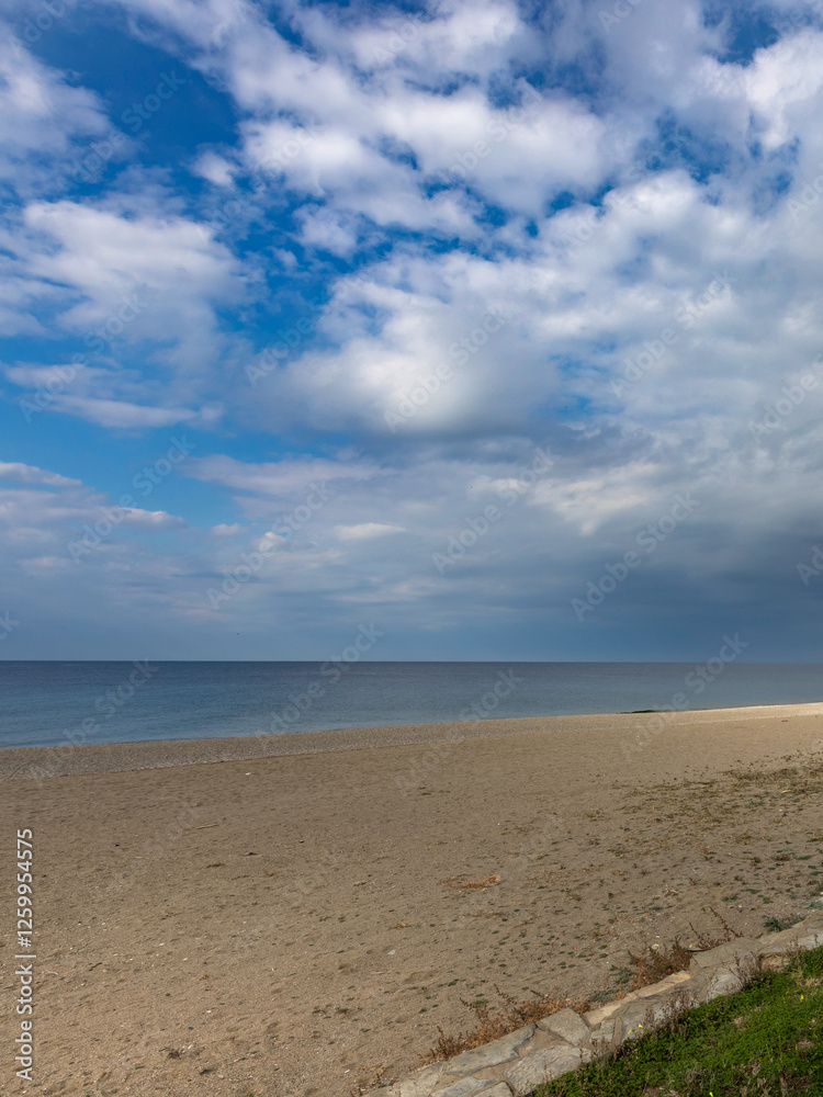 Obraz premium Beach with a cloudy sky in the background