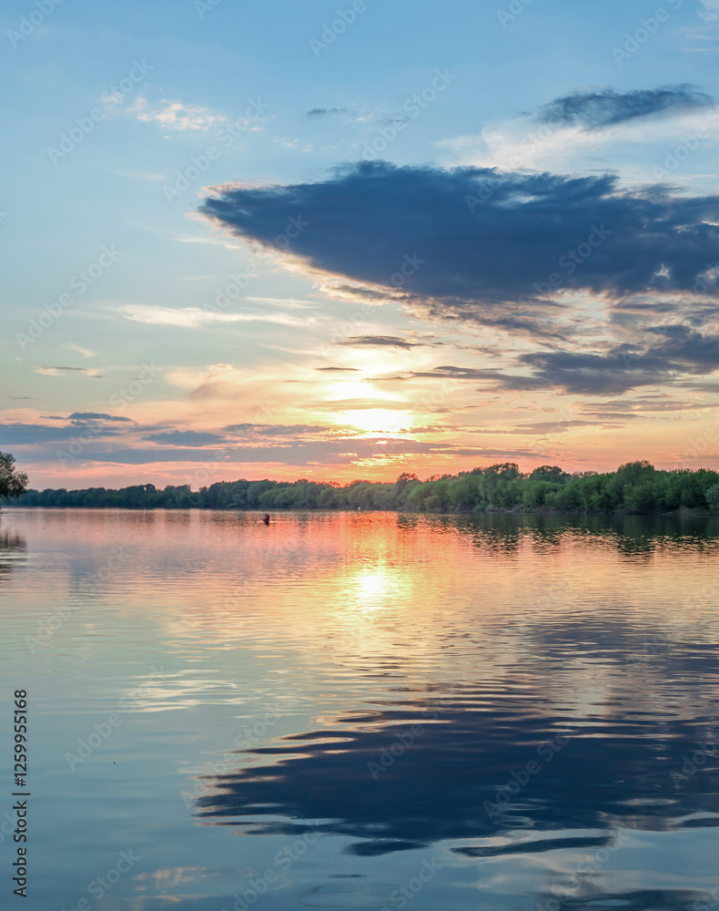 Obraz premium Beautiful sunset over a lake with a reflection of the sun on the water