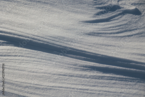 Obraz na płótnie dettagli della superficie di un terreno naturale coperto dalla neve con forme variabili disegnate dal vento ed illuminate dal sole, di giorno, in inverno w salonie