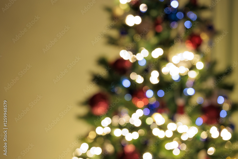 immagine sfuocata da sfondo in tema natalizio con parte di un albero di natale addobbato ed illuminato