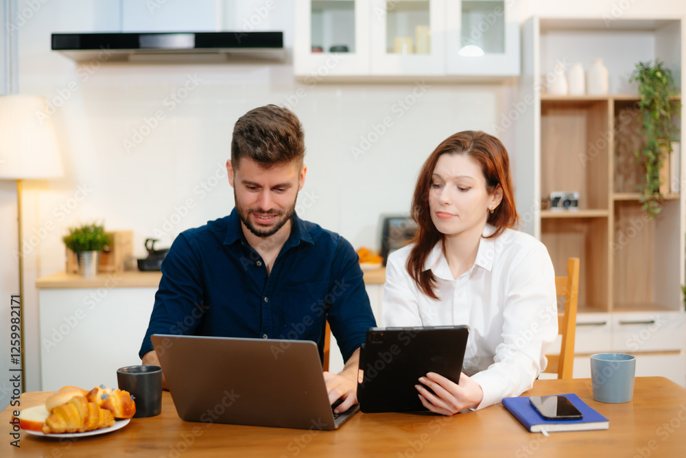 Couple collaborating over coffee in a cozy kitchen setting with a laptop, notebook, and breakfast. Couple collaborating over coffee in a cozy kitchen setting with a laptop, notebook, and breakfast.