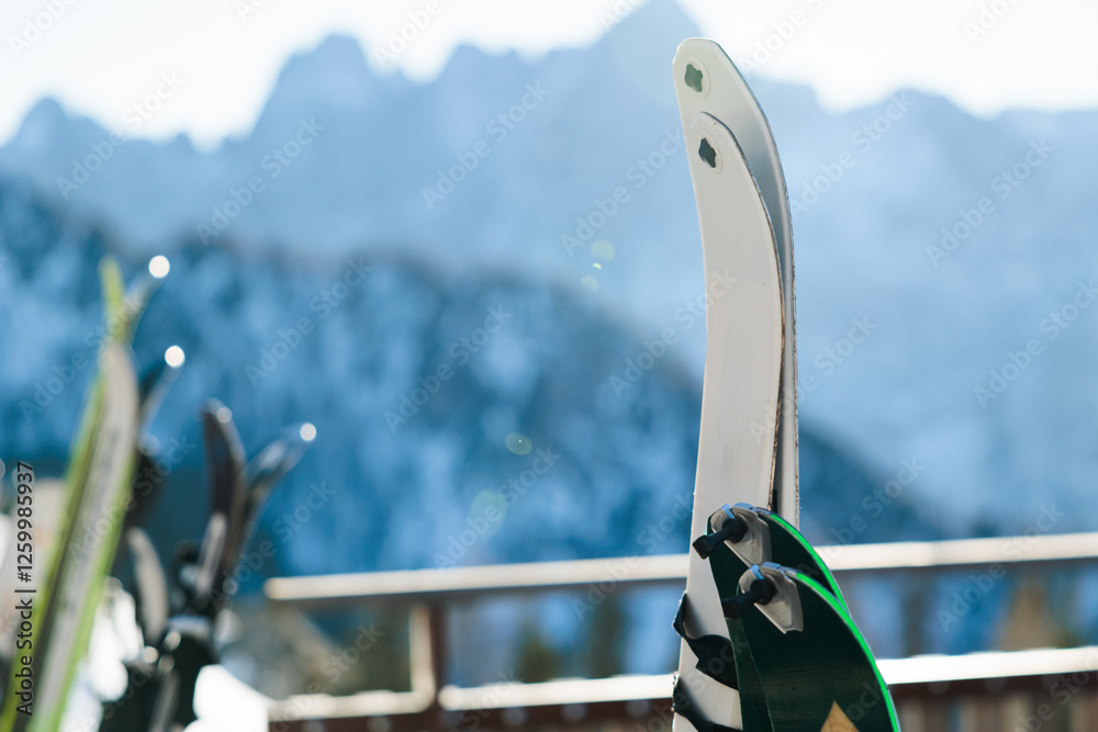 concetto di sport invernale o sciare in inverno. dettaglio di vari paia di sci fermi ed appoggiati ad uno steccato, in un ambiente di montagna, di giorno, in inverno