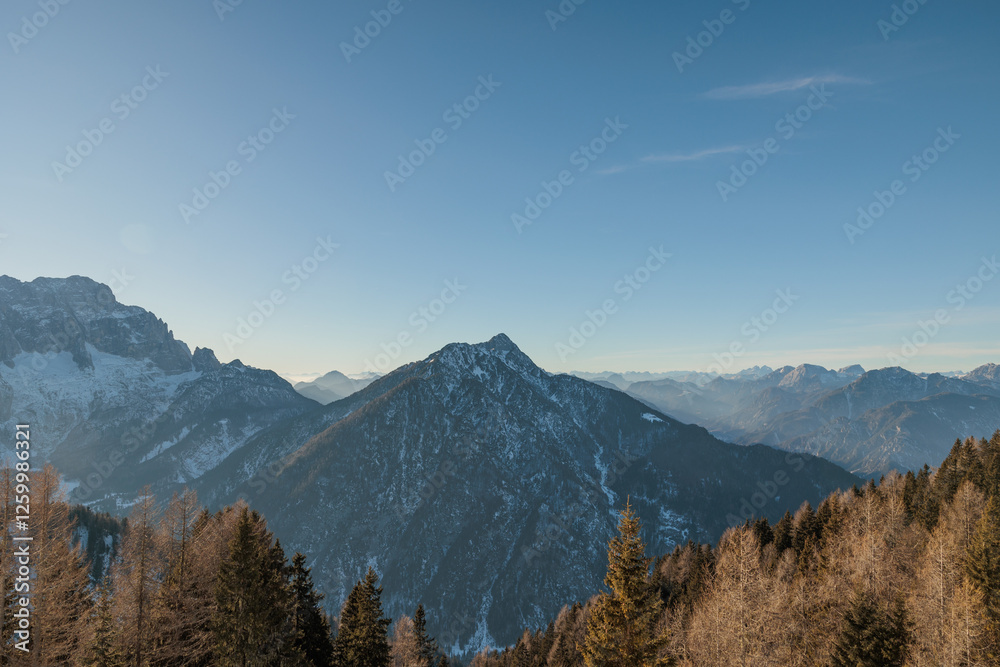 ampia panoramica in alta quota su di un vasto ambiente di montagna innevato, nel Friuli Venezia Giulia nord-orientale, di giorno, con cielo sereno, in inverno