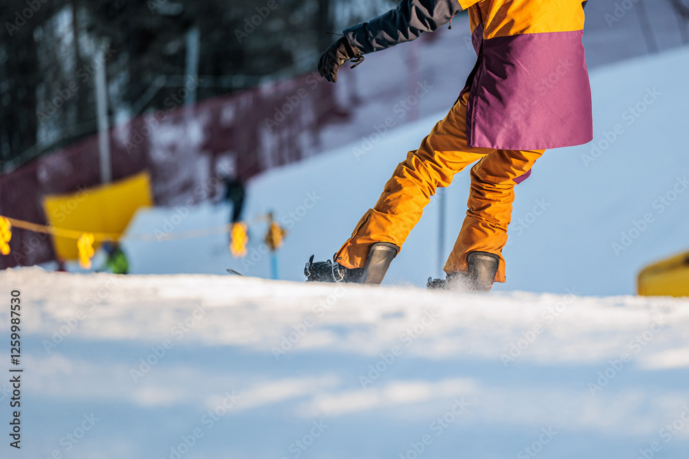 dettaglio di una persona irriconoscibile mentre pratica dello snowboard su una pista da sci, in inverno