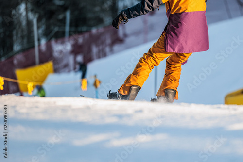 dettaglio di una persona irriconoscibile mentre pratica dello snowboard su una pista da sci, in inverno