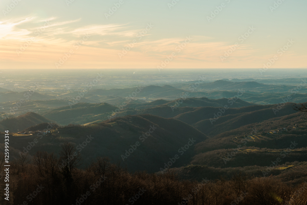 vista da lontano e dall'alto sulla vasta pianura della regione Friuli Venezia Giulia, nell'Italia nord-orientale, che si estende fino all'orizzonte, nel tardo pomeriggio, in inverno