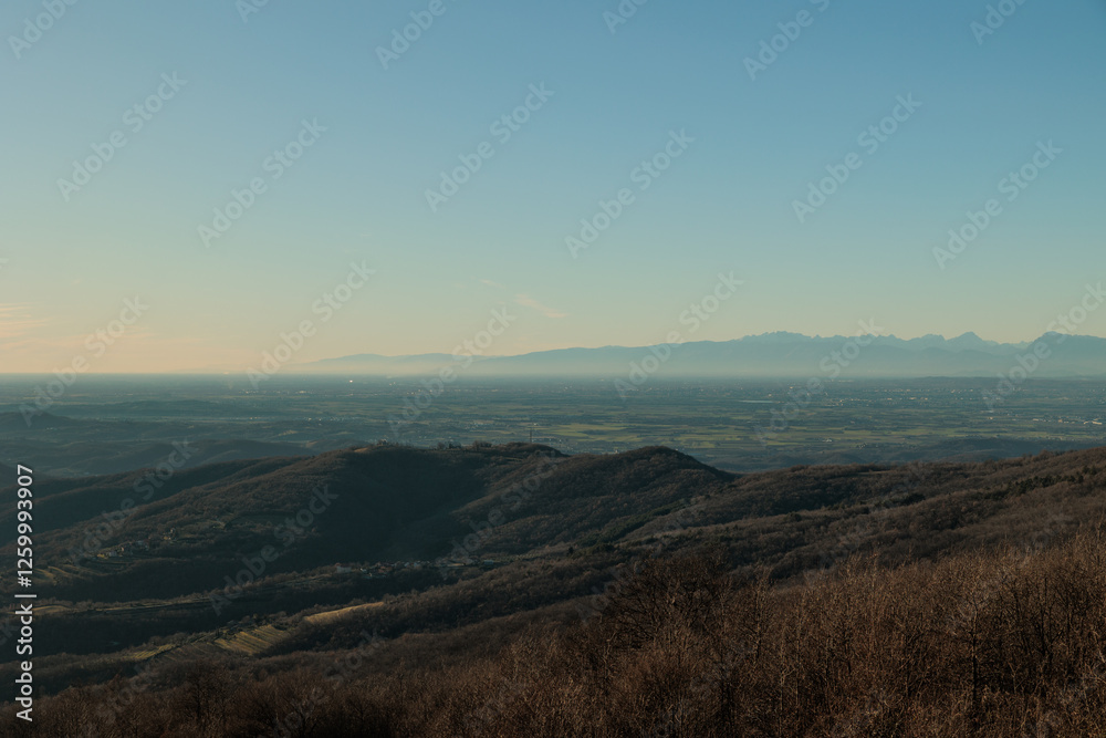 vista da lontano e dall'alto sulla vasta pianura della regione Friuli Venezia Giulia, nell'Italia nord-orientale, che si estende fino all'orizzonte, nel tardo pomeriggio, in inverno