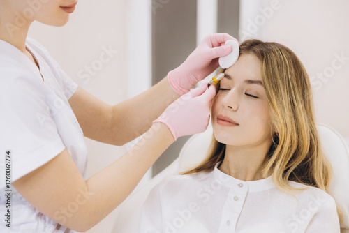 Obraz na plátně Cosmetologist performing rejuvenating injections on a female patient's face in a