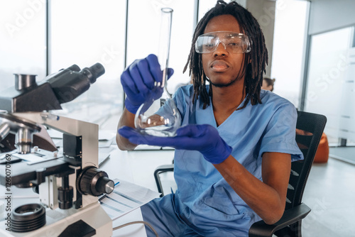 Test tube, microscope. Black man doctor is in the office photo