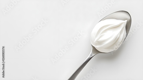 Creamy Whipped Topping on Metal Spoon Against Light Background