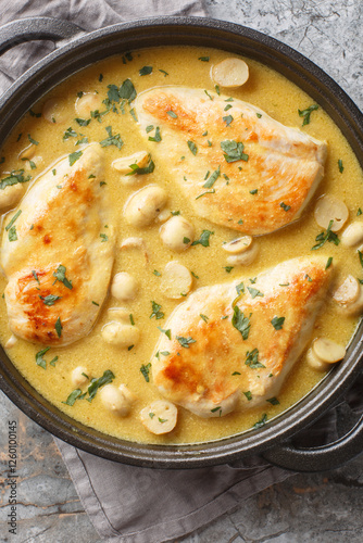 Chicken Diane in a luxuriously creamy sauce, with brandy and mushrooms closeup in the skillet on the wooden board. Vertical top view from above photo