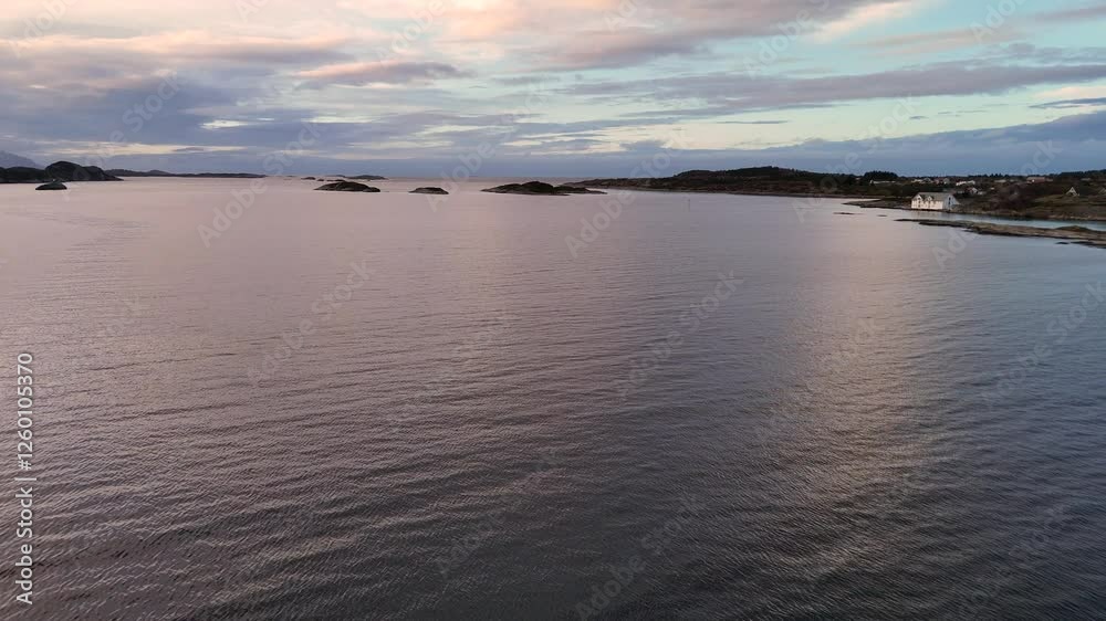 Aerial view from a drone flying over calm waters at sunrise with vibrant sky in Averoey, Norway. Aerial view from a drone flying over calm waters at sunrise with vibrant sky in Averoey, Norway.