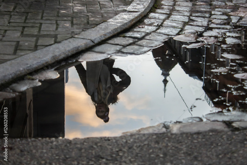 Reflection of a Woman and Cityscape in a Puddle photo