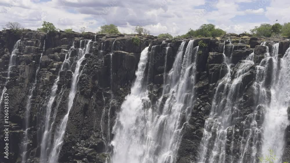 Majestic aerial view of Victoria Falls, cascading water over rocky cliffs, Zambia Majestic aerial view of Victoria Falls, cascading water over rocky cliffs, Zambia