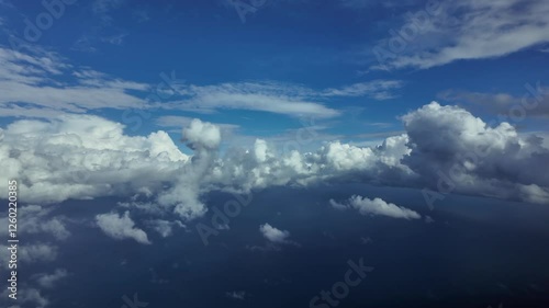 Flying over the Mediterraean Sea as seen by the pilots from an airplane cockpit, with some cottony clouds ahead under a deep blue sky. 4K 60FPV