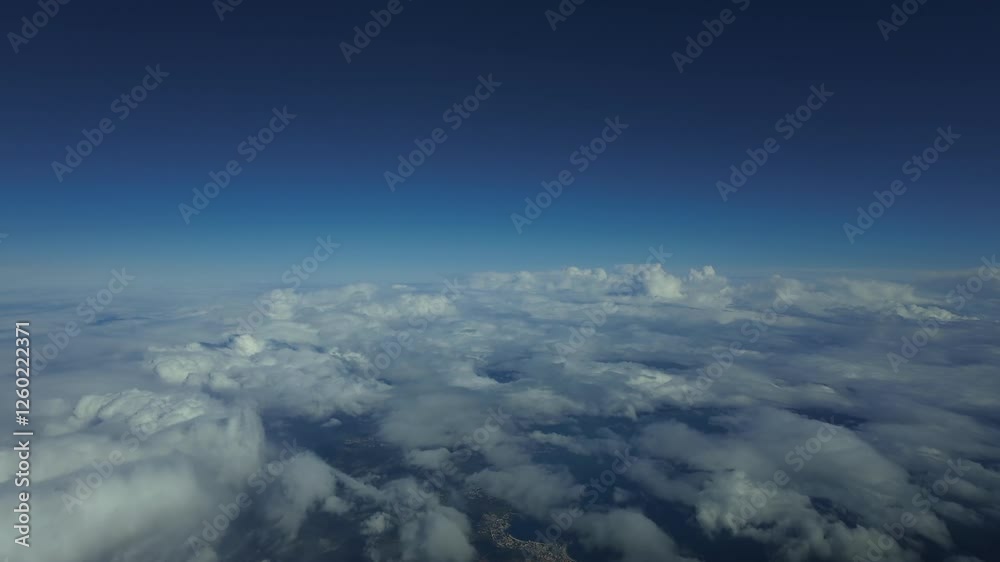 An immersive pilot’s FPV perspective from a jet cockpit flying over some cottony clouds at supersonic spped and under a blue sky. 4K. Hyperlapse.