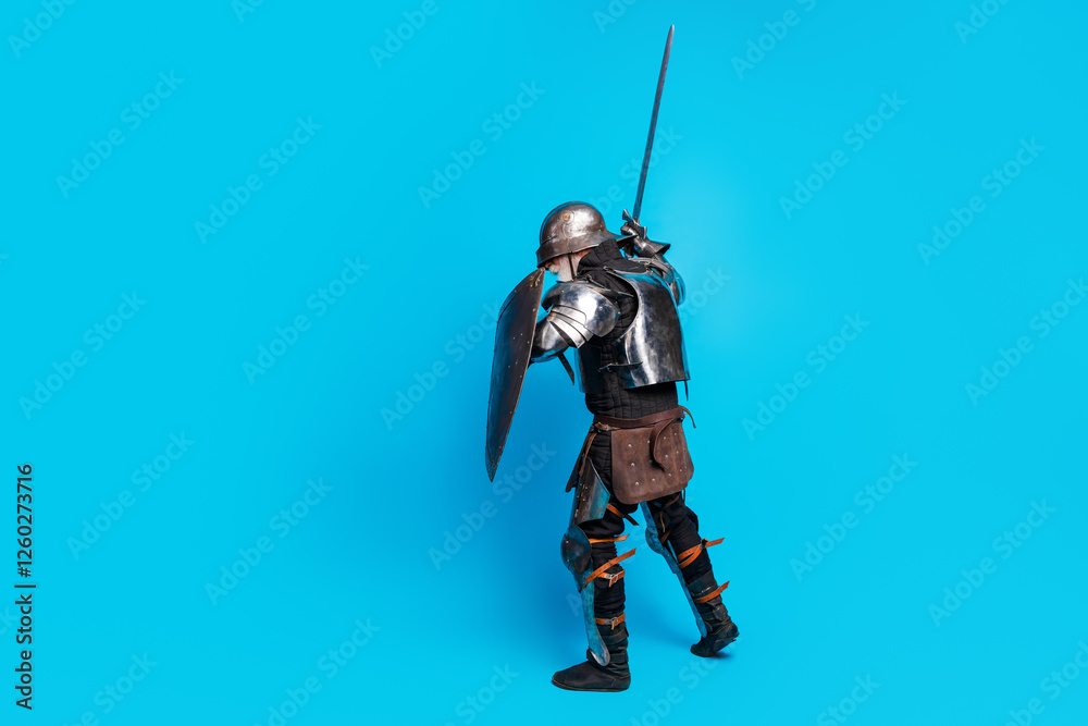 A medieval knight in metallic armor wielding a sword and shield against a vibrant blue background, exuding bravery and classic style. A medieval knight in metallic armor wielding a sword and shield against a vibrant blue background, exuding bravery and classic style.