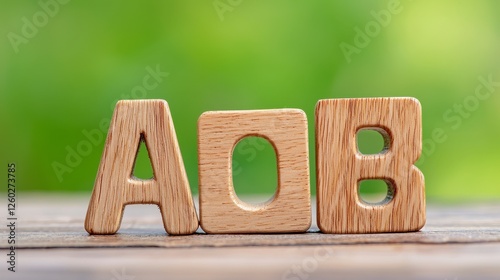 Wallpaper Mural Light Brown Wooden Letters AOB on Wooden Surface with Blurred Green Background Torontodigital.ca