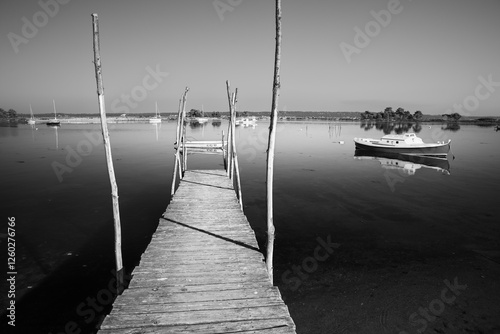 Wooden pier and boats anchored in Mimbeau lagoon off Cap Ferret, Arcachon, Gironde department, Nouvelle-Aquitaine, France, Europe photo