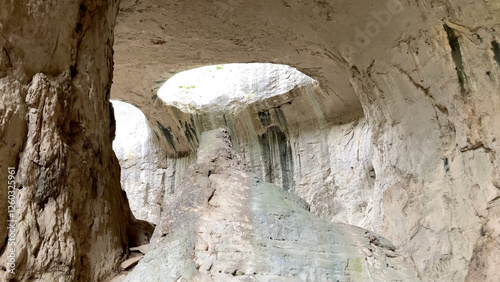 Prohodna Cave in Bulgaria, featuring the iconic God's Eyes openings, a natural rock formation resembling eyes. Majestic natural wonder. Dramatic light filters from the holes above - Karlukovo, Europe photo