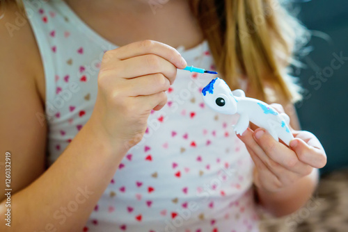 Obraz na płótnie Little girl painting animal figure with colors. School child making homework for school project. Happy kid with eyeglasses holding brush. w salonie