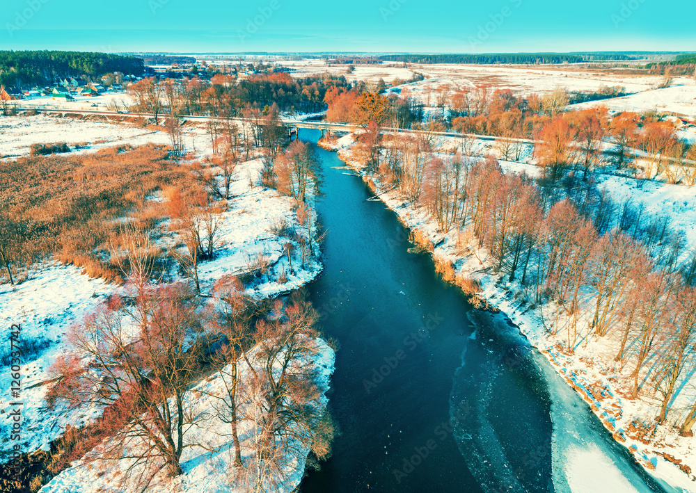 Aerial view of unfrozen river in the countryside on a sunny winter day