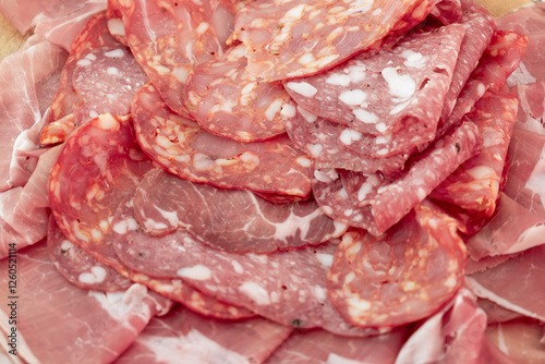 Banquet cold cuts set. Banquet menu with slices of sausage, ham, on a wooden cutting board.