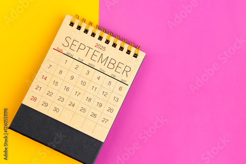 September 2025 desk calendar made from brown paper page on multicolor background. photo