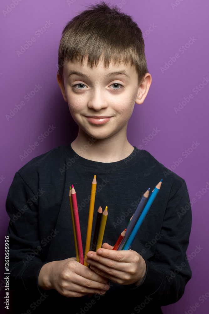 A young student’s hands holding multiple colored pencils, symbolizing creativity, learning, and artistic expression. Close-up shot with a bright purple background. A young student’s hands holding multiple colored pencils, symbolizing creativity, learning, and artistic expression. Close-up shot with a bright purple background.