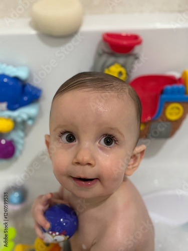A baby boy playing in the bath