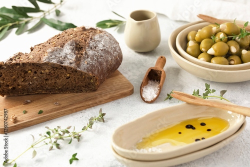 A rustic arrangement of bread, olive oil and olives stuffed with almonds.