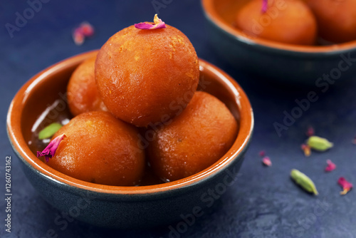 A bowl of gulab jamun on blue background photo