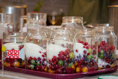 Candy bar with different kinds of fruit and berries in glass jars.
