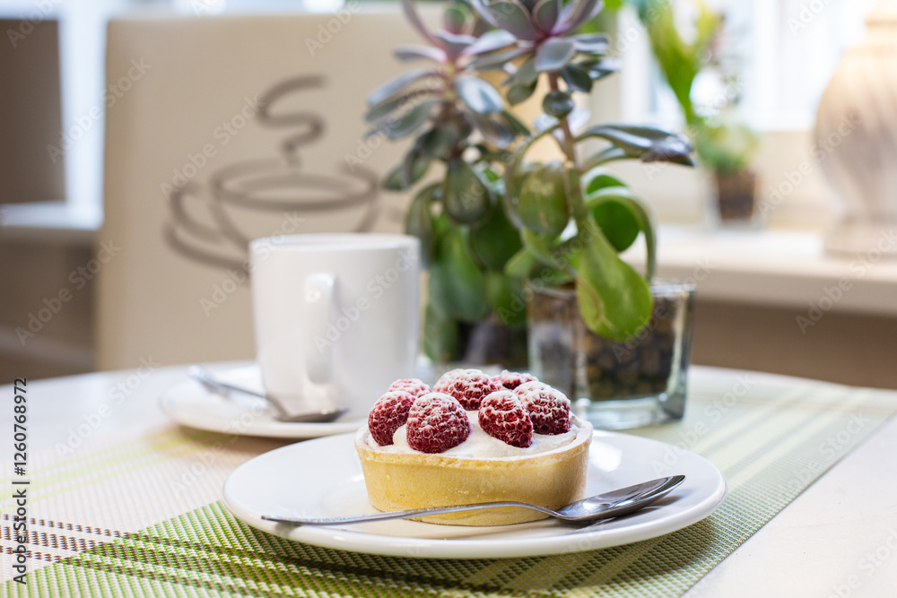 Raspberry tart with cup of coffee on the table in cafe