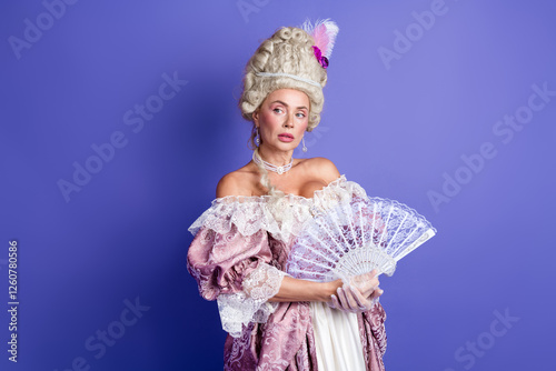 Elegant woman in a baroque style costume with lavish details against a purple backdrop photo