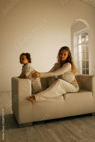 Mother and child. Mother and baby playing in sunny room. Parent and little child relaxing at home. Family having fun together.