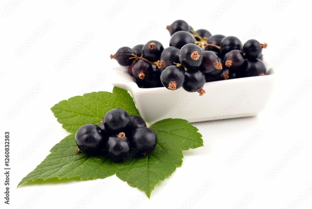 Black currant in white bowl with green leaves isolated on white background. Black currant in white bowl with green leaves isolated on white background.