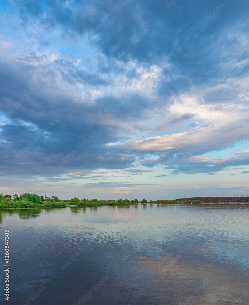 Fototapeta premium Calm lake with a cloudy sky in the background